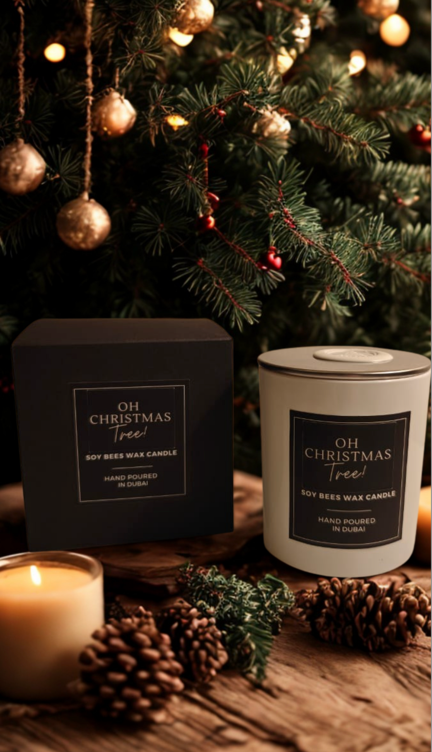 Two candles labeled 'Oh Christmas Tree' in front of a decorated Christmas tree.