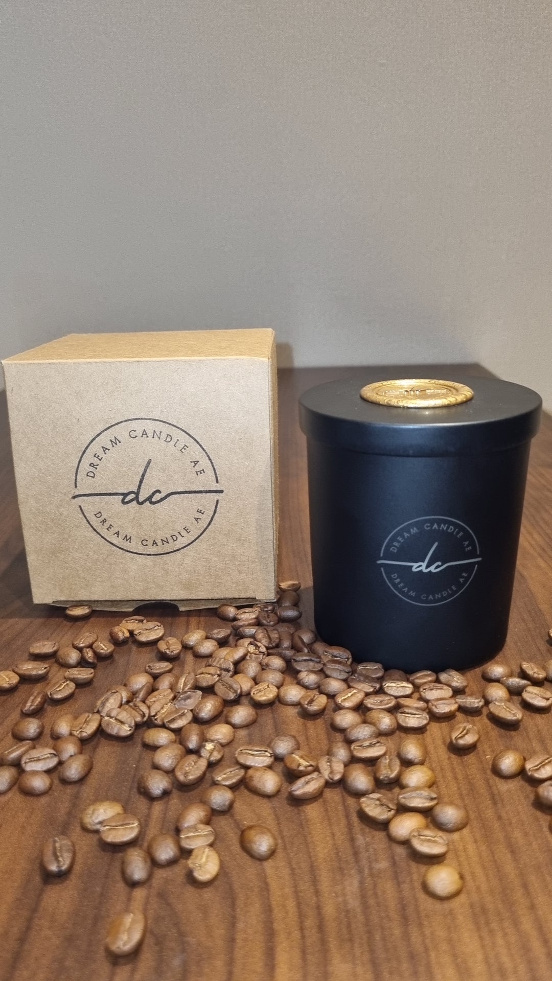 Fresh Brew Coffee scented candle in a matte black glass surrounded by coffee beans. 